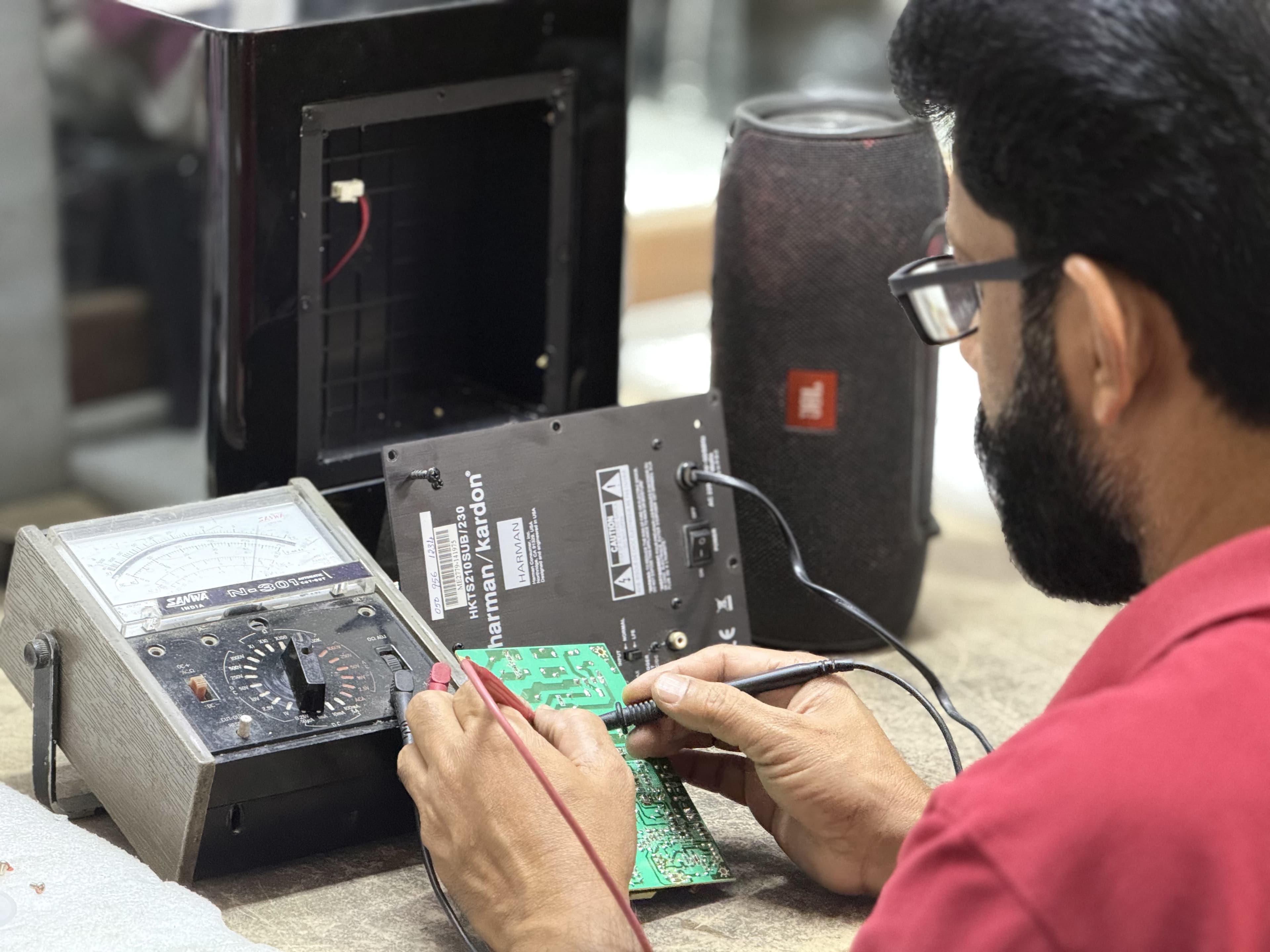 Technician repairing a JBL Bluetooth speaker
