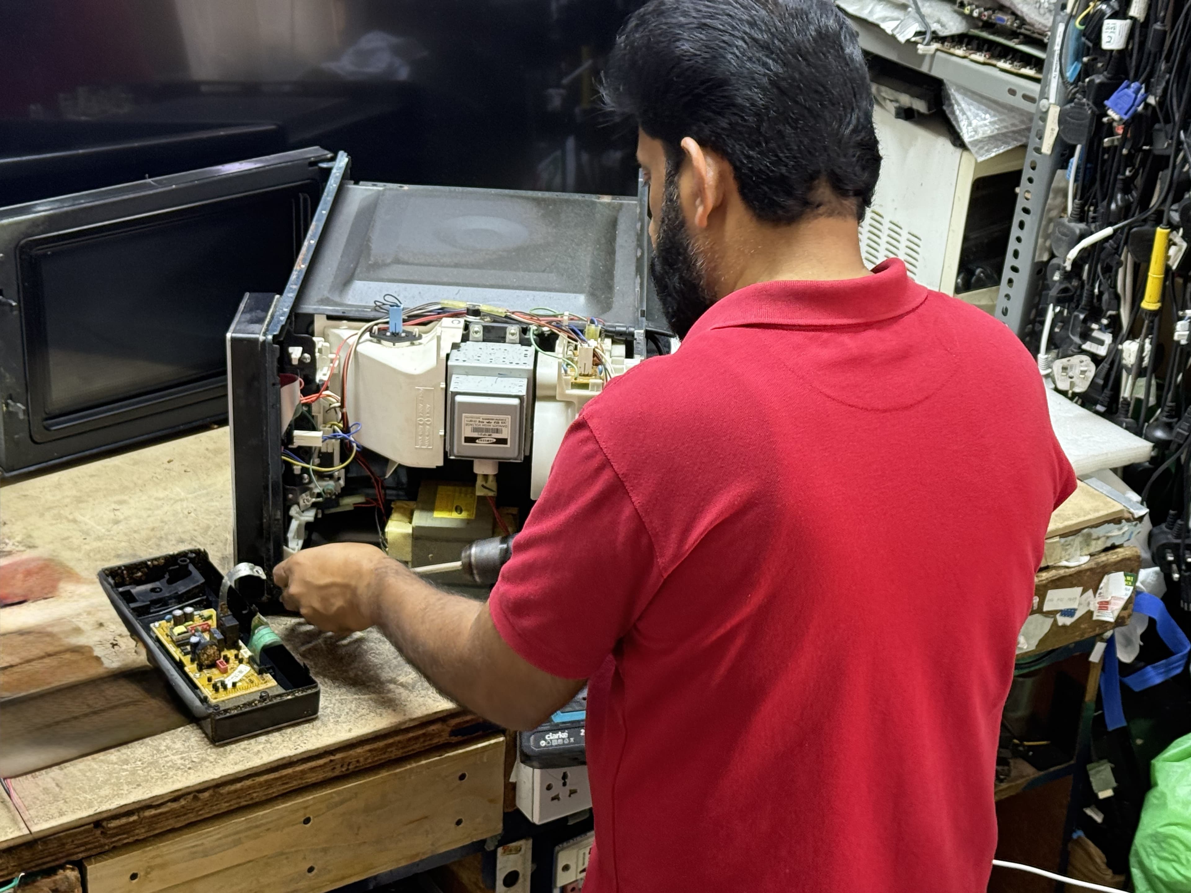 Technician repairing a microwave oven control board